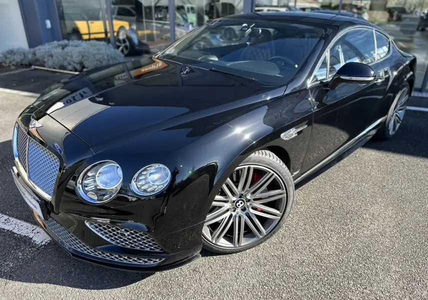 Bentley Continental GT Speed noire vue 3/4 avant droit, avec jantes alliage et calandre chromée distinctive.