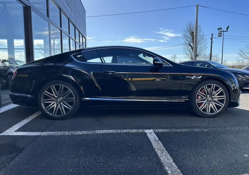 Profil côté gauche d'une Bentley Continental GT Speed noire de 2015, avec jantes alliage et étriers rouges visibles.
