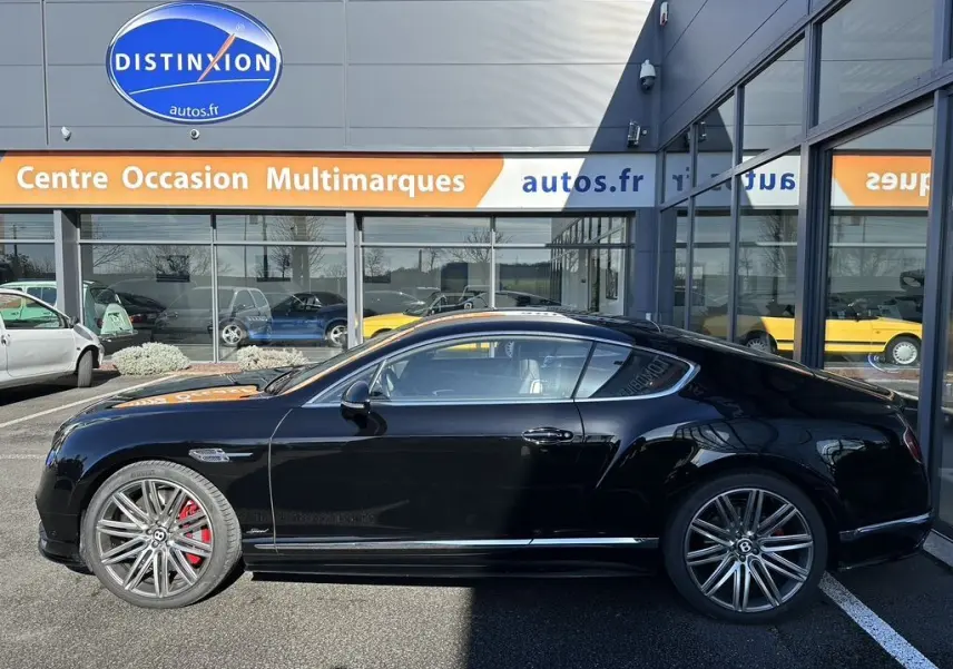 Profil latéral droit d'une Bentley Continental GT Speed noire de 2015 avec jantes alliage et étriers de frein rouges.