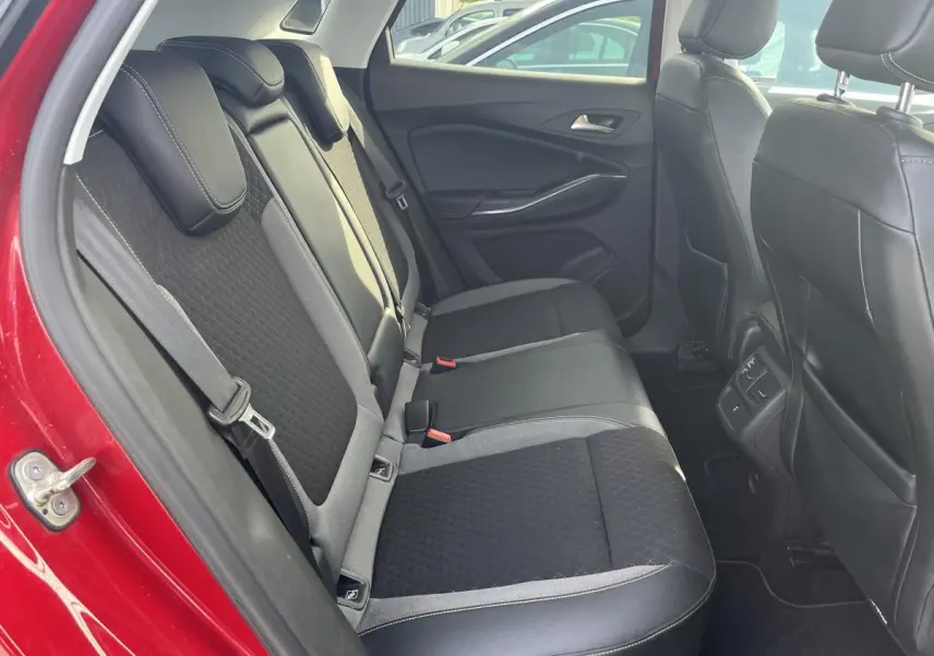 Vue côté gauche des sièges arrière noirs et gris dans l'habitacle d'un Opel Grandland rouge 2018.