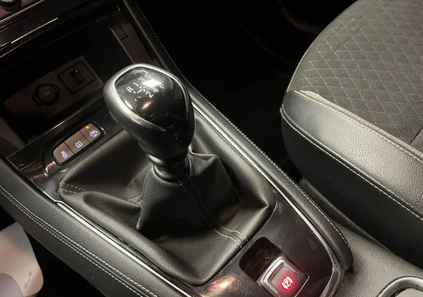 Gros plan sur le levier de vitesses manuel et la console centrale noire de l'Opel Grandland X 1.6 CDTI rouge.
