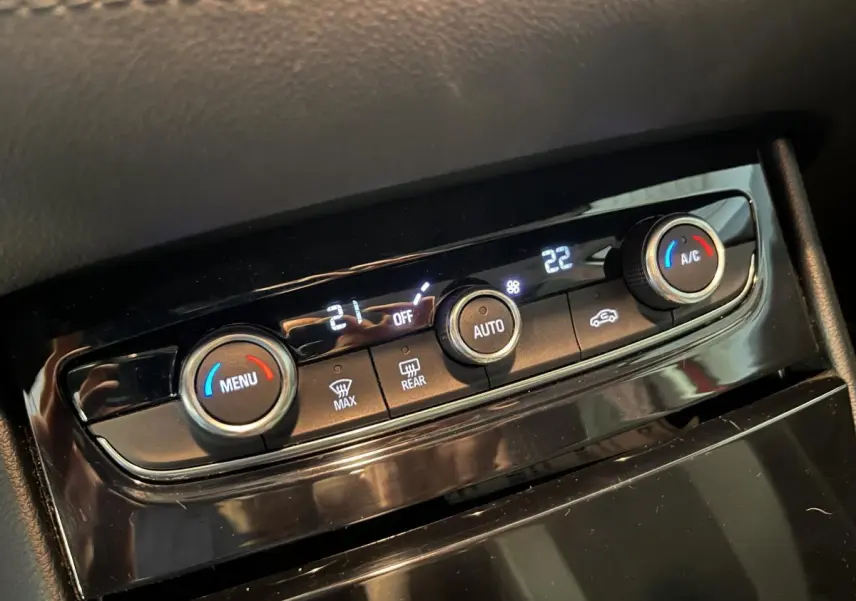 Gros plan sur la commande de climatisation automatique bi-zone noire de l’Opel Grandland rouge de 2018.