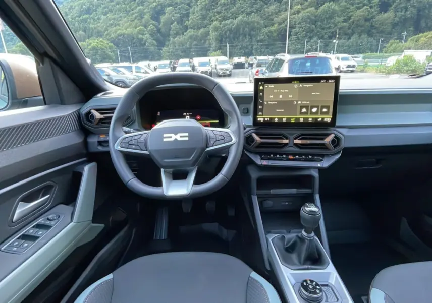 Intérieur du Dacia Bigster TCE 130 4x4 Extreme Plus 2025, vue frontale sur le volant, tableau de bord et levier de vitesse manuel.