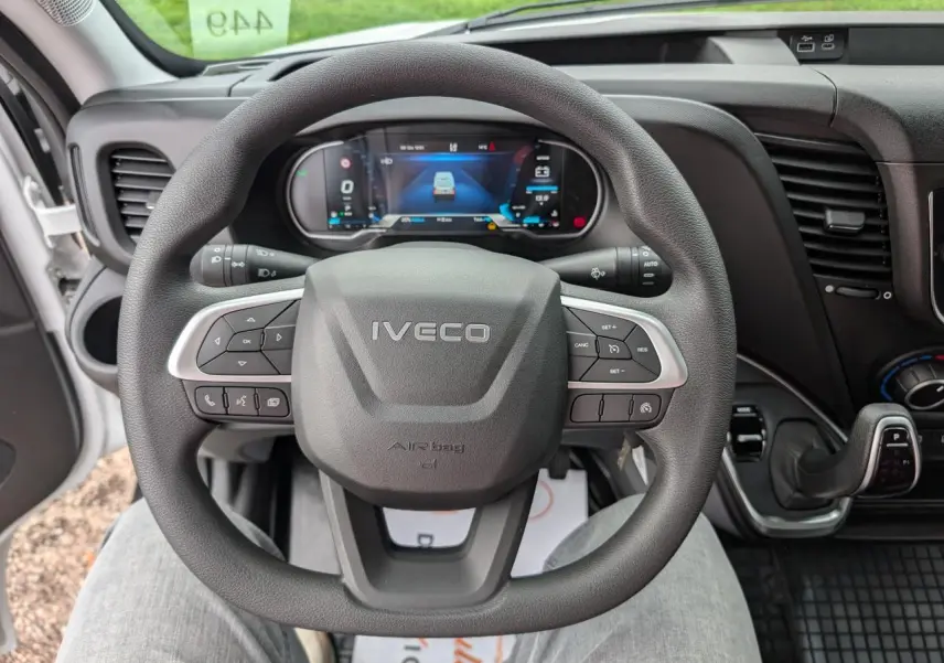 Vue intérieure centrée sur le volant IVECO du Daily 35S16 2025 avec tableau de bord numérique et commandes intégrées.