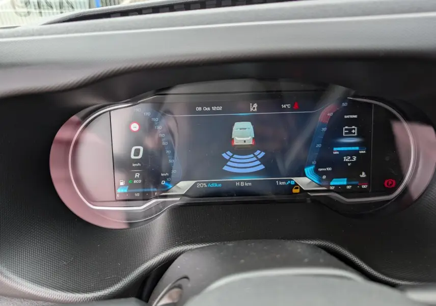 Tableau de bord numérique du Daily IVECO 35S16, affichant la vitesse, batterie et assistance au stationnement.