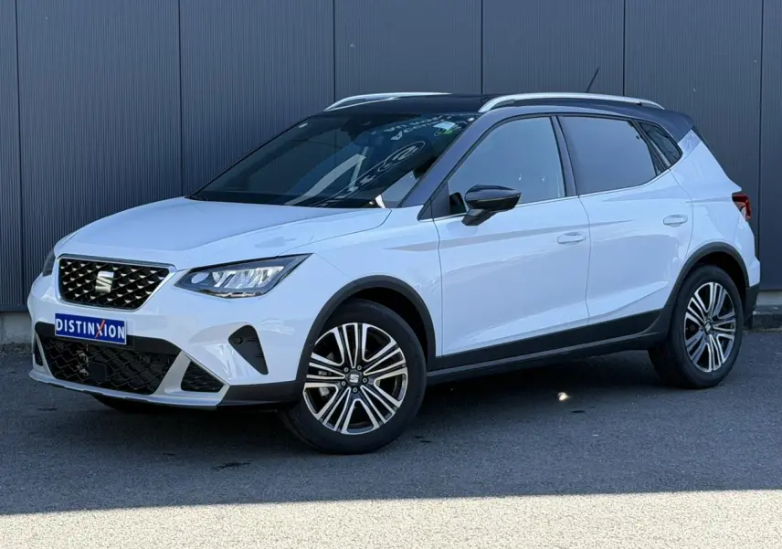 SEAT Arona blanc Nevada avec toit noir, vue 3/4 avant droit, jantes alliage 17 pouces et calandre chromée.