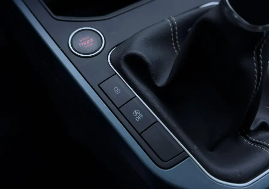 Gros plan sur la console centrale noire avec bouton Start/Stop et levier de vitesses en cuir du SEAT Arona TSI 115 Xpérience.