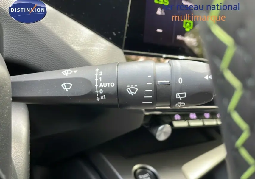 Gros plan sur la commande d’essuie-glace à gauche du volant d’une Peugeot 308 gris Artense hybride 2026.