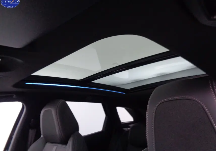 Toit panoramique avec éclairage d'ambiance bleu et sièges noirs en tissu dans un Peugeot 3008 2023.