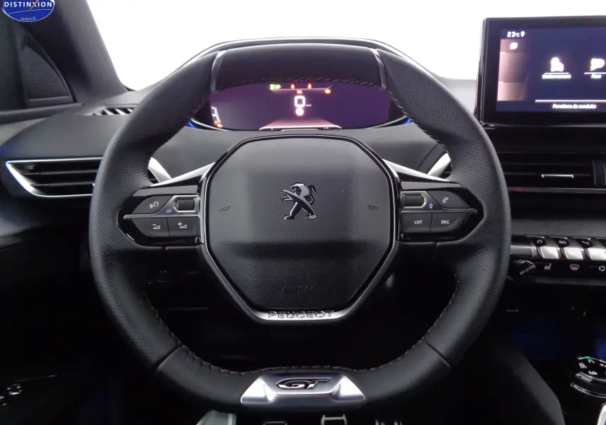 Volant cuir noir avec logo Peugeot et badge GT, tableau de bord numérique et écran tactile dans un Peugeot 3008 2023.