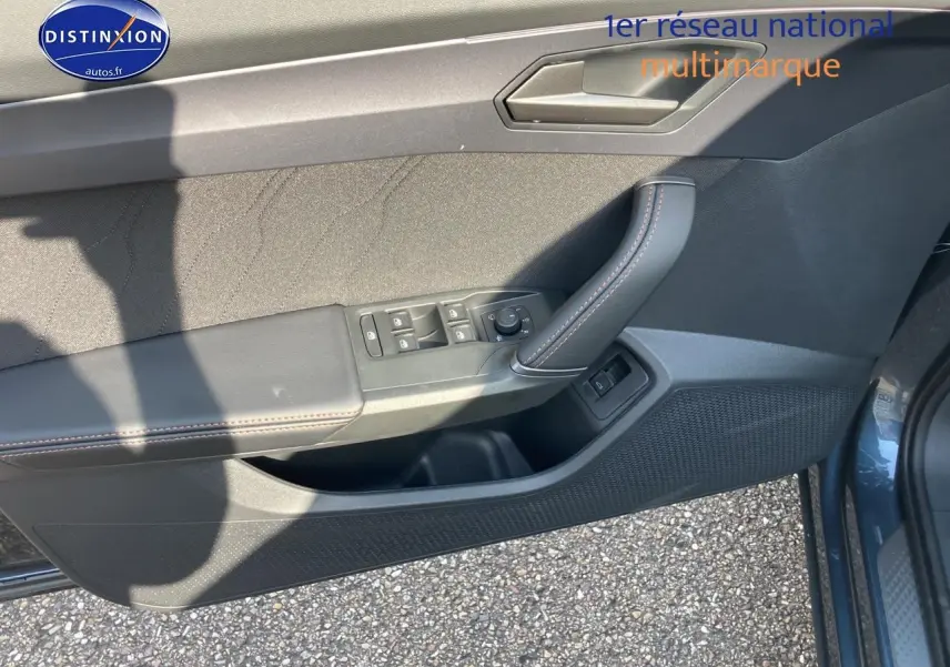 Vue du panneau de porte avant gauche du CUPRA Formentor gris magnétique avec commandes électriques et surpiqûres contrastées.