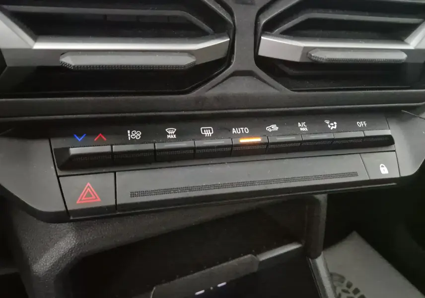 Vue rapprochée des commandes de climatisation automatique du tableau de bord du Dacia Duster noir 2024.