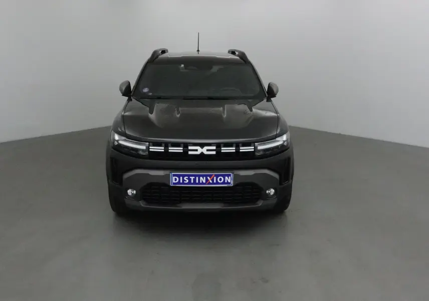 Vue frontale d'un Dacia Duster noir 2024 avec calandre moderne et plaques Distinxion visibles.