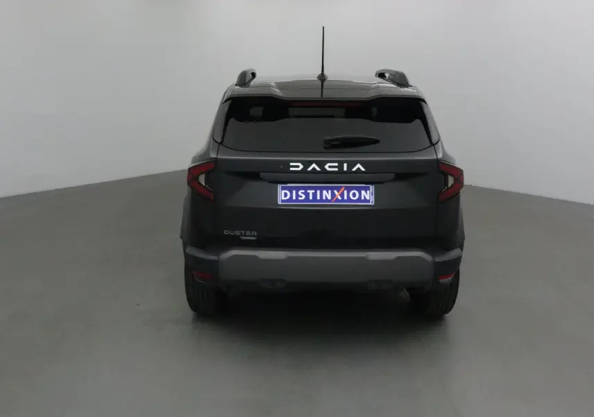 Vue arrière d'un Dacia Duster noir 2024 avec logo distinctif et plaque Distinxion visible.