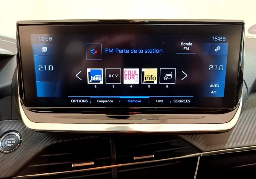 Écran tactile central de 7 pouces affichant la radio dans l'habitacle noir du Peugeot 208 Gris clair 2020.