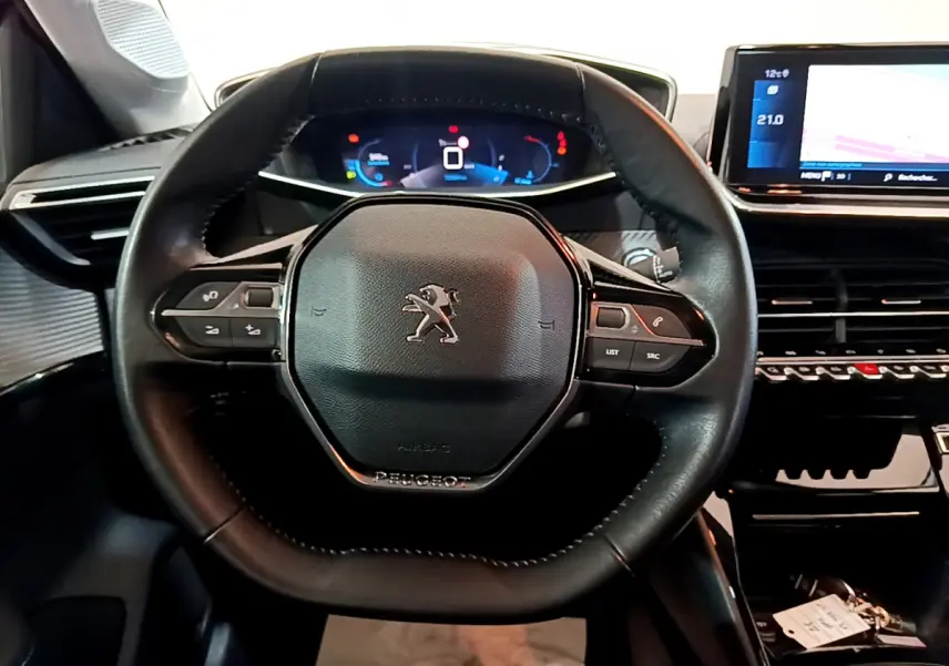 Vue rapprochée du volant cuir multifonctions et du tableau de bord numérique de la Peugeot 208 PureTech 100 S&S Allure Business.