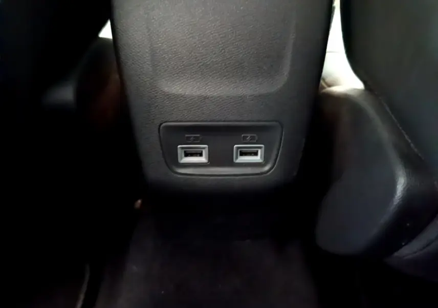 Vue rapprochée des deux ports USB situés à l'arrière de la console centrale d'une Peugeot 208 gris clair.