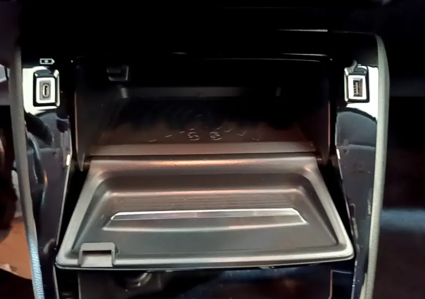 Vue rapprochée de la zone de rangement centrale avec recharge sans fil et ports USB sur Peugeot 208 gris clair 2020