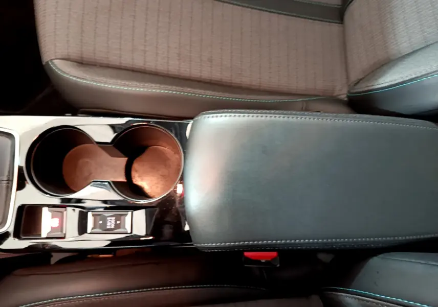 Vue rapprochée de la console centrale en cuir noir et porte-gobelets du Peugeot 208 gris clair 2020 PureTech Allure Business.