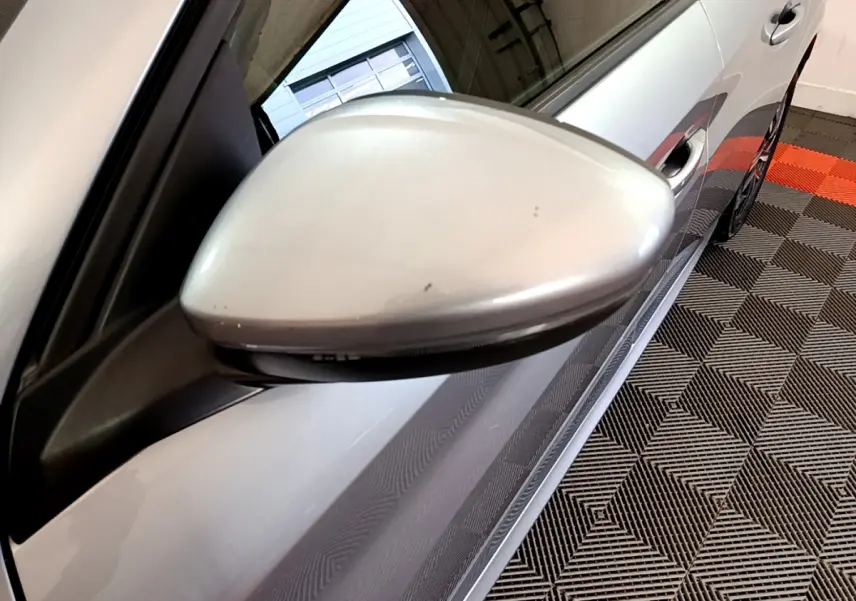 Rétroviseur côté gauche gris clair de la Peugeot 208 PureTech 100 S&S Allure Business, vue rapprochée en intérieur.