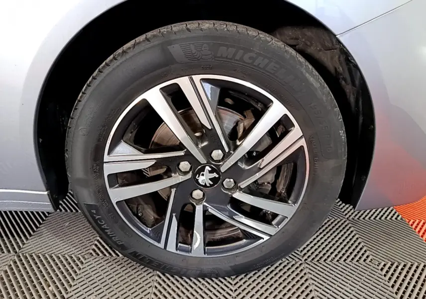Gros plan sur la roue avant gauche gris clair de la Peugeot 208 PureTech 100 avec jante alliage et pneu Michelin.