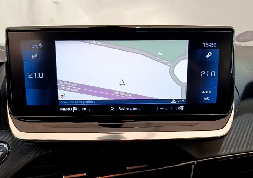 Écran tactile central de navigation affichant une carte, avec commandes climatisation à 21°C sur Peugeot 208 gris clair.