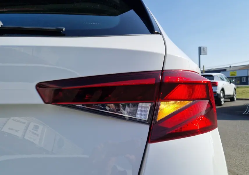 Feu arrière droit allumé sur une Skoda Fabia berline blanche vue de près en extérieur par temps clair.