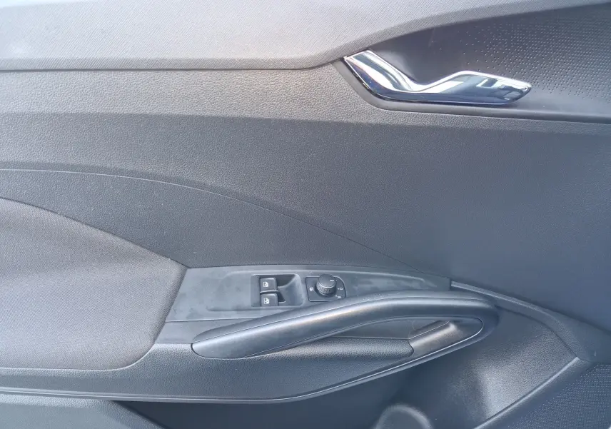 Détail de la porte intérieure côté conducteur de la Skoda Fabia blanche 2022, avec commandes des vitres et rétroviseurs.