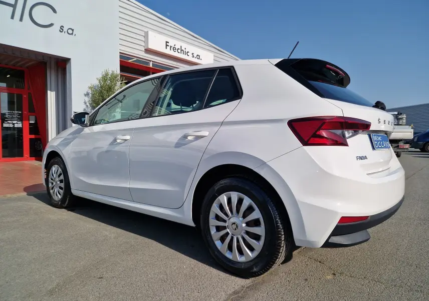 Vue 3/4 arrière droite d'une Skoda Fabia Berline Active blanche 2022, avec jantes alliage et feux arrière distinctifs.