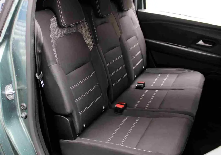 Vue intérieure côté gauche sur la banquette arrière noire avec surpiqûres blanches du Dacia Jogger vert cèdre 2025.