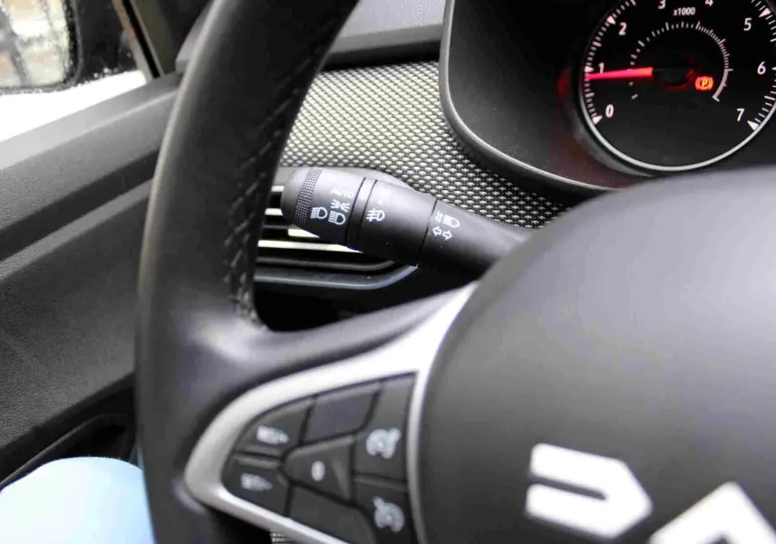 Gros plan sur le volant noir et la manette de clignotant du tableau de bord du Dacia Jogger 2025.