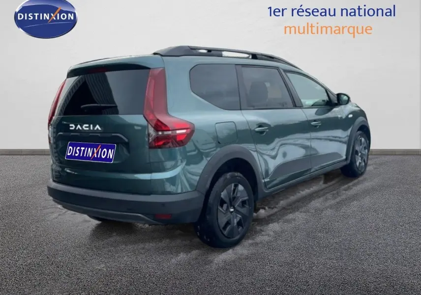 Vue 3/4 arrière droite d'un Dacia Jogger 2025 vert cèdre métal avec toit ouvrant et vitres teintées.