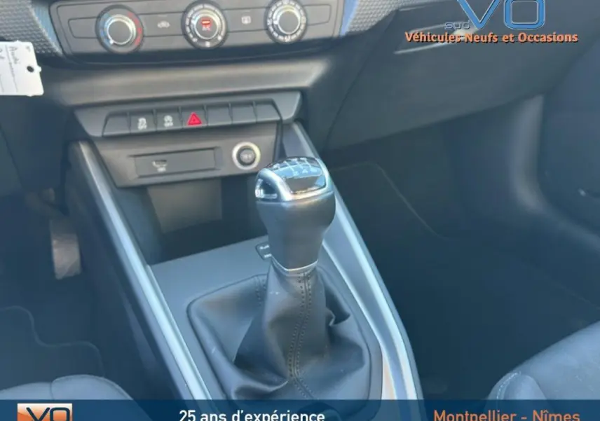 Gros plan sur le levier de vitesses manuel en cuir noir de l'Audi A1 Sportback 30 TFSI, avec console centrale grise.