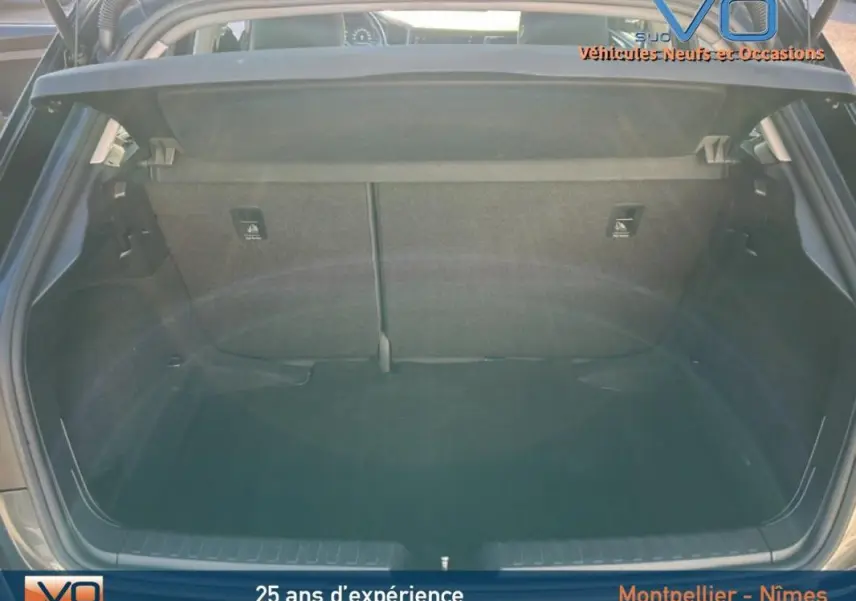 Coffre ouvert vu de l'arrière d'une Audi A1 Sportback gris foncé, montrant l'espace de chargement vide et la tablette cache-bagages.