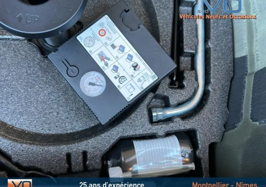 Gros plan sur le coffre d'une Audi A1 Sportback gris foncé de 2019 montrant le kit de réparation pneus et outils rangés.