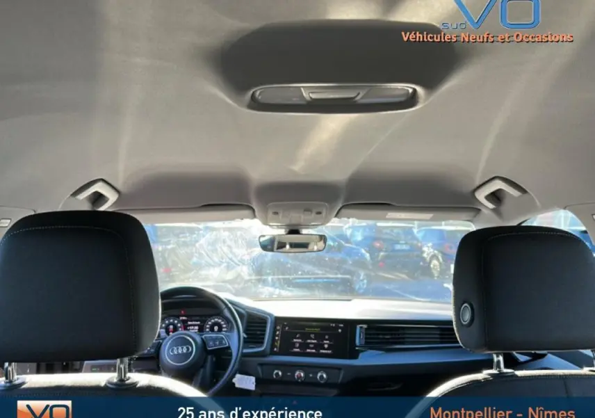 Vue intérieure avant de l'Audi A1 Sportback gris foncé 2019, montrant le volant cuir et le cockpit numérique.