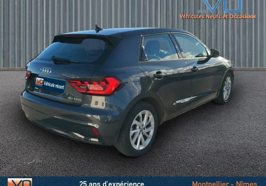 Audi A1 Sportback gris foncé vue 3/4 arrière droit, jantes 16 pouces et feux arrière LED visibles.