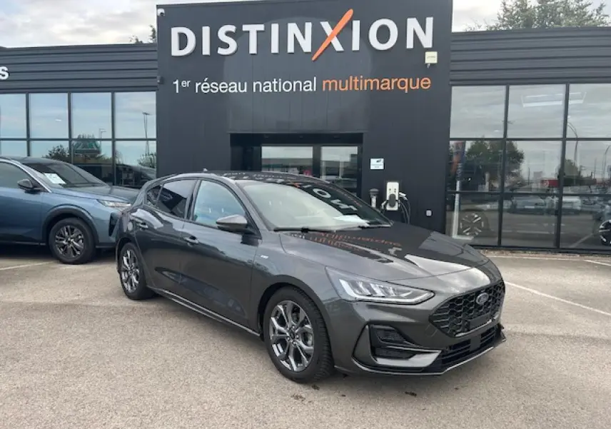 Ford Focus IV ST-Line X gris Magnetic Metal vue 3/4 avant avec calandre noire et jantes alliage 17 pouces.