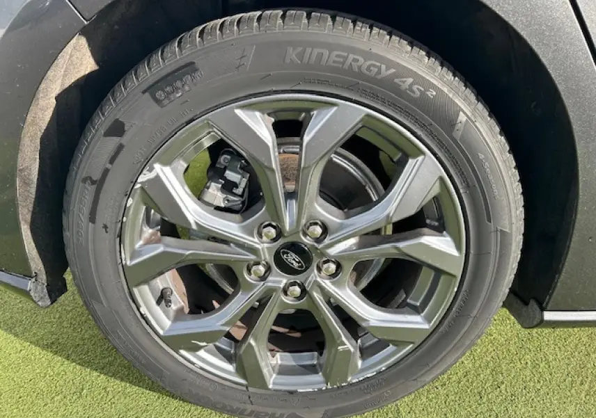 Gros plan sur la jante alliage 17'' à 5 branches de la Ford Focus IV gris Magnetic Metal, avec logo Ford central.