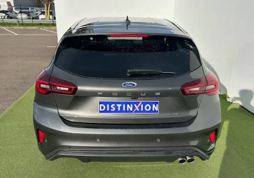 Vue arrière d'une Ford Focus IV ST-Line gris magnetic métal avec double sortie d'échappement et feux LED.