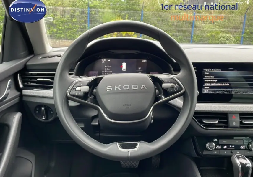Vue intérieure centrée sur le volant SKODA d’un KAMIQ 2025, avec tableau de bord digital et écran tactile gris graphite.