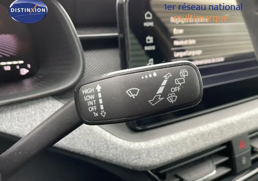 Gros plan sur la commande d’essuie-glace du Skoda Kamiq 2025, intérieur gris graphite avec écran tactile en arrière-plan.