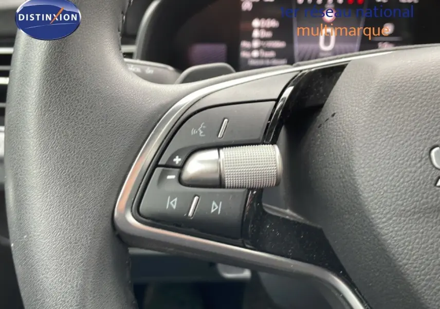 Gros plan sur la commande multimédia au volant du Skoda Kamiq 2025 gris graphite métal, avec molette texturée et boutons intégrés.