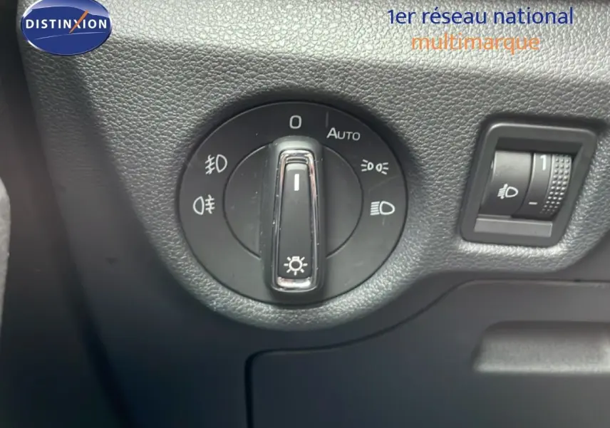 Gros plan sur le bouton de commande des phares dans l'habitacle du Skoda Kamiq gris graphite 2025.