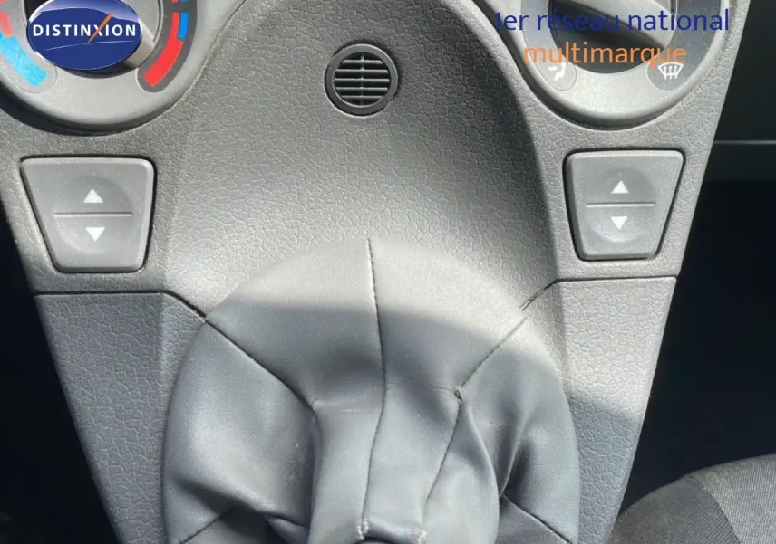 Gros plan sur la console centrale de la Fiat Panda blanche, mettant en valeur le levier de vitesses manuel et les commandes de climatisation.