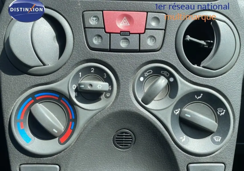 Gros plan sur les commandes de climatisation et ventilation du tableau de bord d'une Fiat Panda blanche de 2011.
