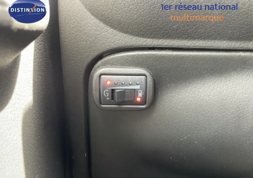Détail du tableau de bord montrant l'interrupteur de sélection essence/GPL dans une Fiat Panda blanche 2011.