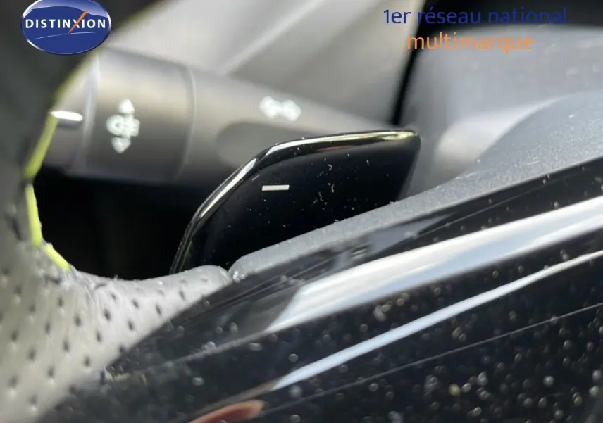 Gros plan sur la palette de changement de vitesse noire côté droit du volant perforé d'une Peugeot 308 gris Artense 2026.