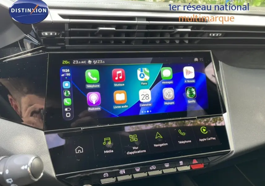 Vue rapprochée de l’écran tactile central du tableau de bord de la Peugeot 308 gris Artense, affichant Apple CarPlay.