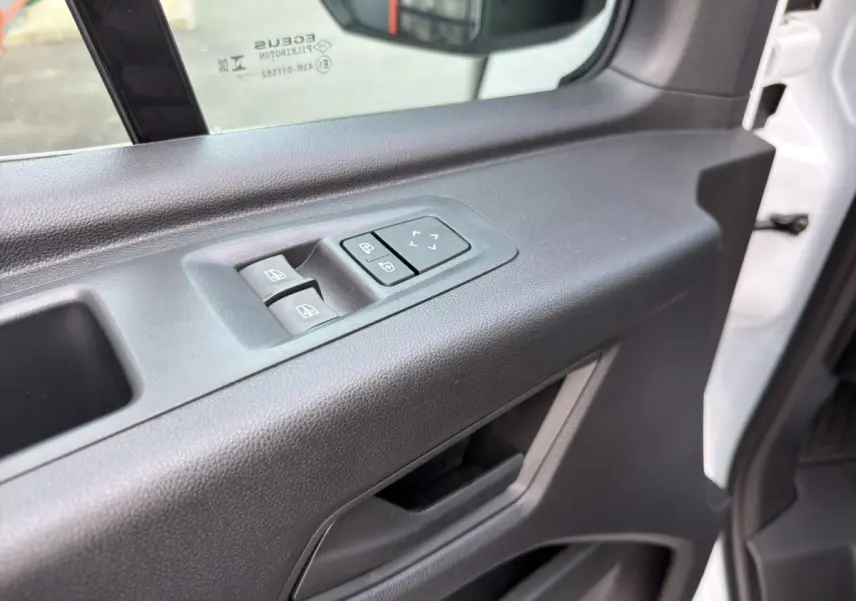 Détail de la porte côté conducteur du Renault Master blanc 2026, avec commandes électriques des vitres et réglage des rétroviseurs.
